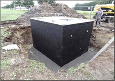 Arbeiter beim Brunnenbau in Bruchhausen-Vilsen, Niedersachsen, mit Rohrleitungen im Vordergrund.
