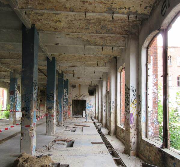 Historisches Gebäude des ehemaligen Wäschereistandorts Rewatex in Berlin-Spindlersfeld, umgeben von urbaner Landschaft.