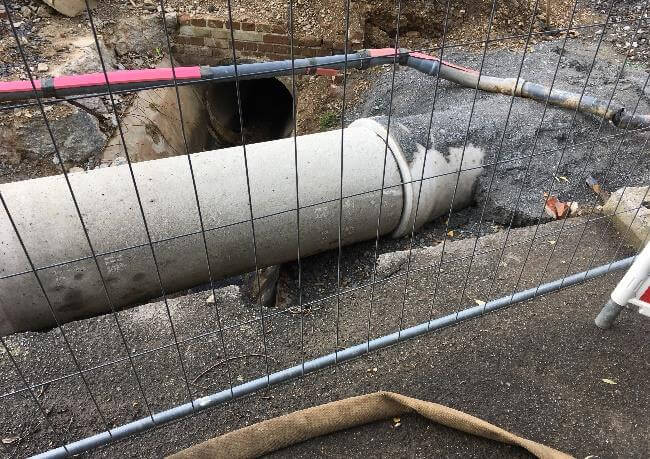 Bauarbeiten zur hydraulischen Sanierung des Kanals in Eitorf, Dehlenbachweg, mit Maschinen und Baustellenpersonal.