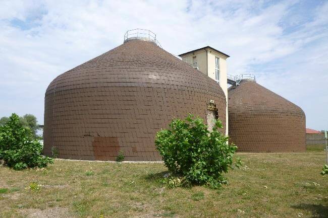 Blick auf die neu errichteten Betriebsgebäude der Kläranlage Schkopau, umgeben von Baustellenmaterialien und Maschinen.